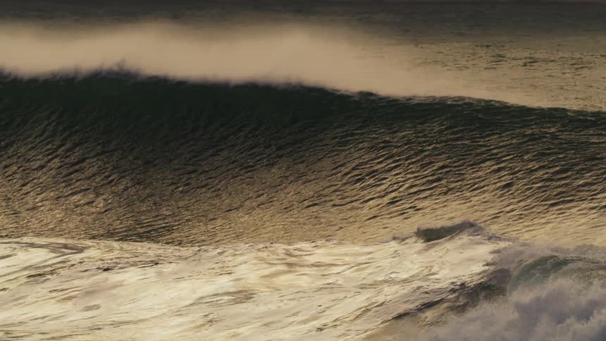 Surfer waits on a swelling wave during the day