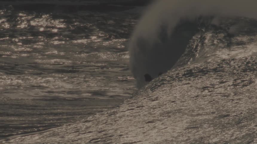 Two people surfing together on big ocean waves in the sea