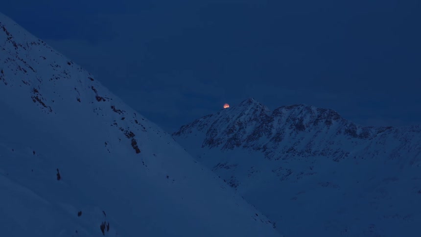 Landscape of a snowy mountain with the moon on the horizon