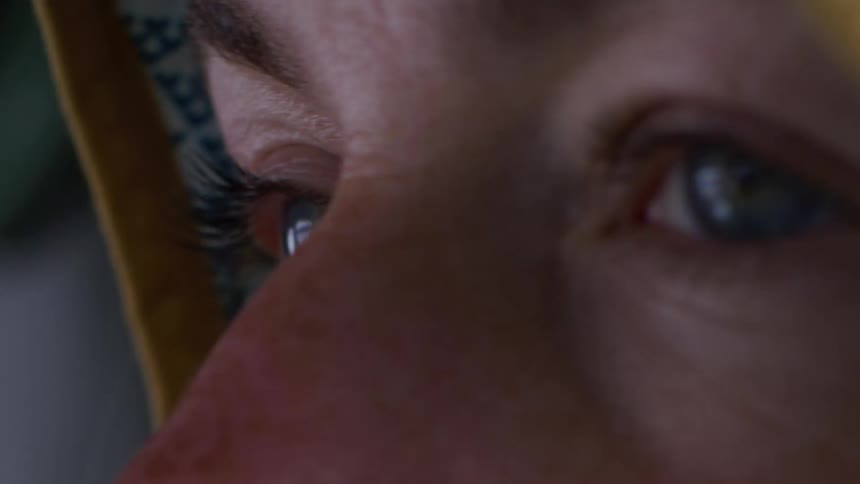 Closeup shows a persons eyes reflecting an external scene