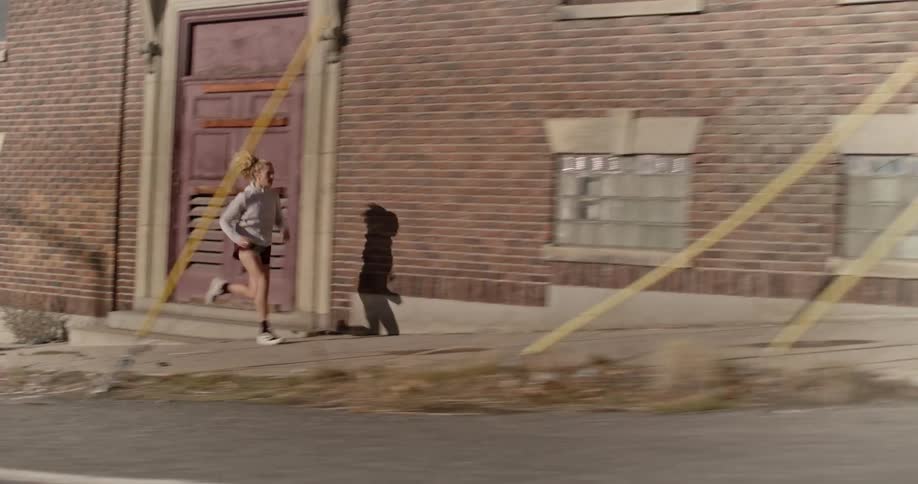 A woman is seen jogging through a suburban city