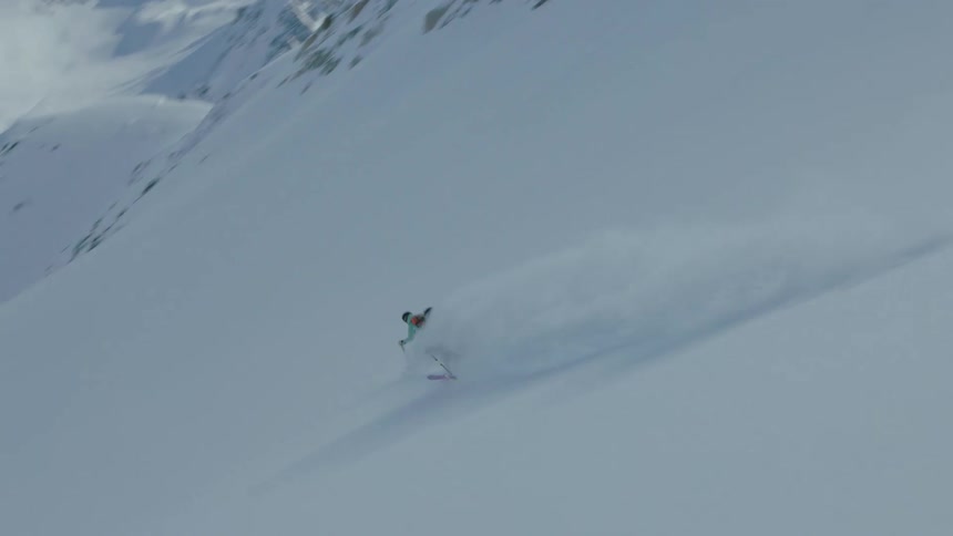 Two people skiing down a snow covered mountain