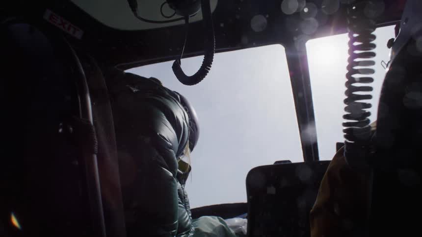 Two people in the cabin of a helicopter in operation