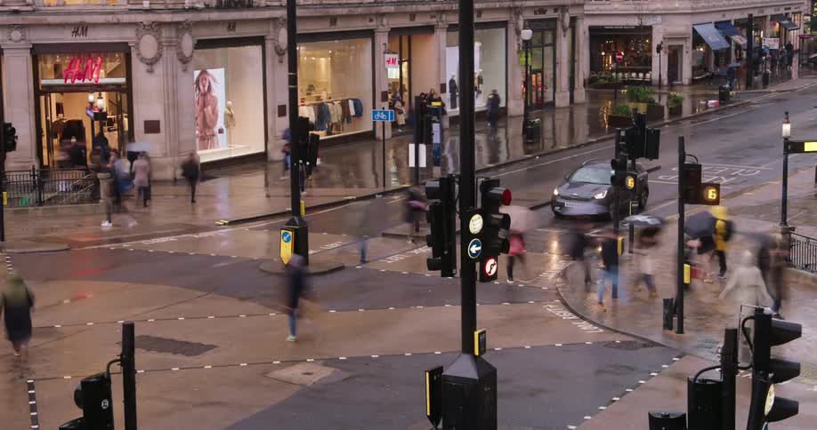 Pedestrians and vehicle traffic on a wet urban road in a metropolis