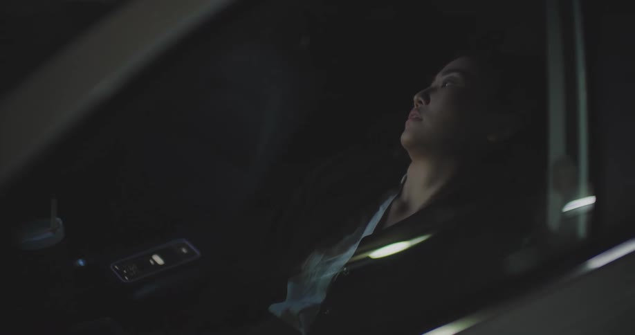 Office worker taking a nap in her car exits the vehicle and hurries away after being woken by her phone alarm