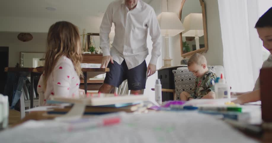 A daughter throws a soccer ball at her dad to get his attention