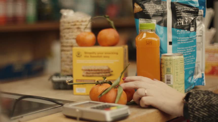 Person places food products on a payment counter