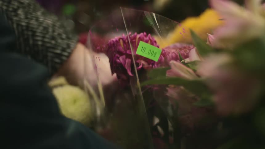 Person touches a bouquet of flowers