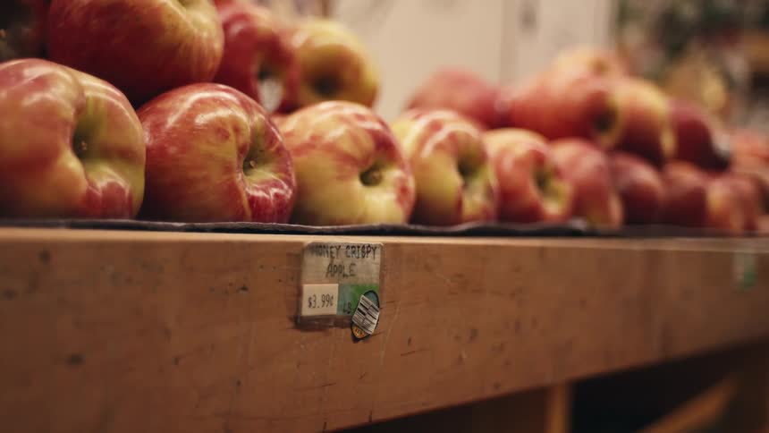 Hand picking apples in a grocery store