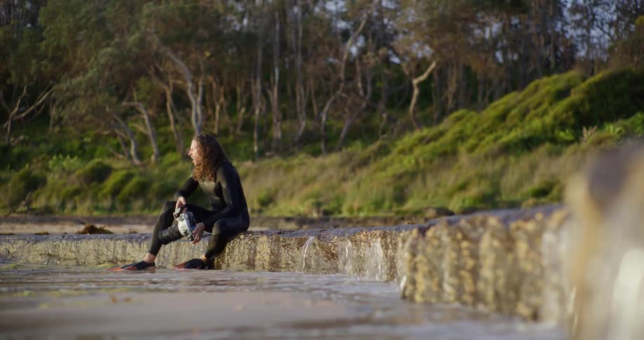 A footage of a man seated by the stream