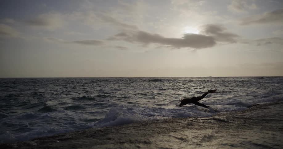 A person dives into the rough tide