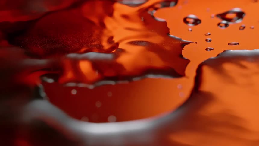 A clip of a water droplet on an orange surface