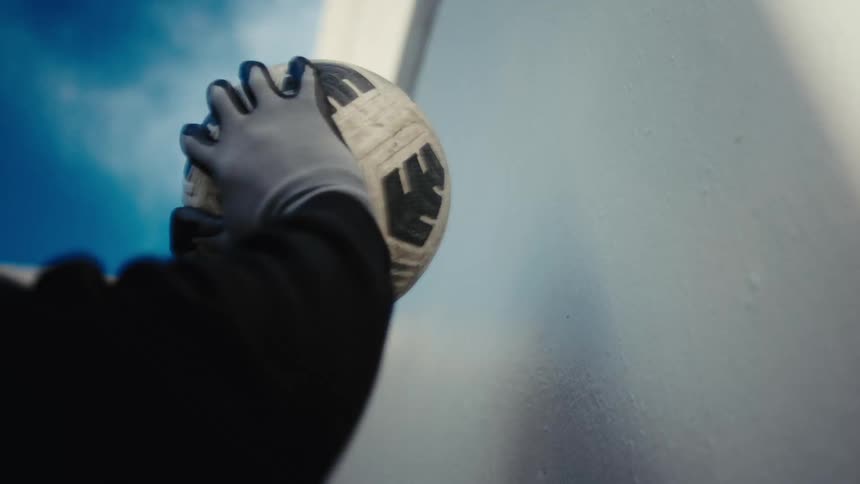 Hand with goalkeeper glove hitting the ball against the wall