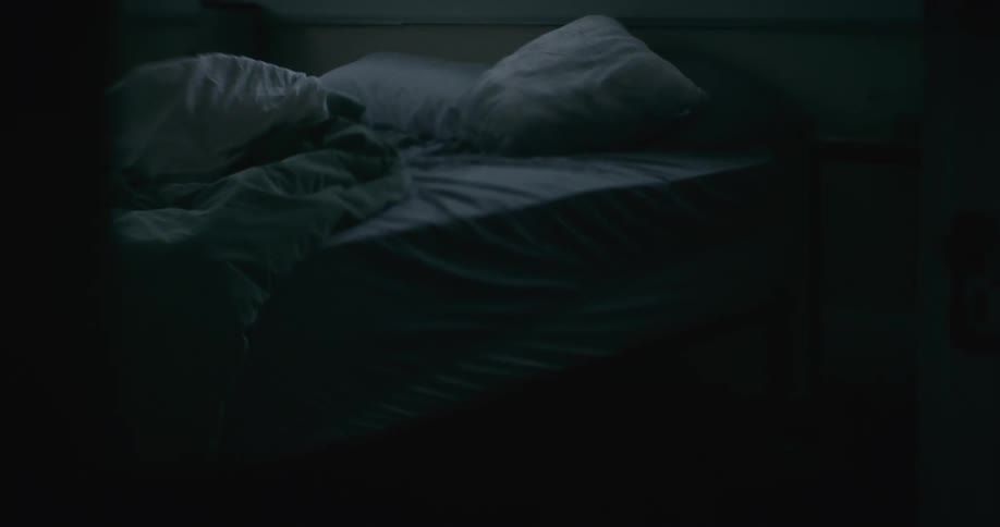 Unmade slept in bed in a dark room