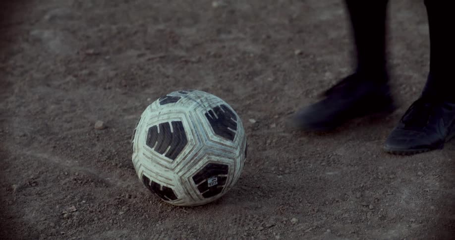 Person placing a ball on the sand field and kicking it