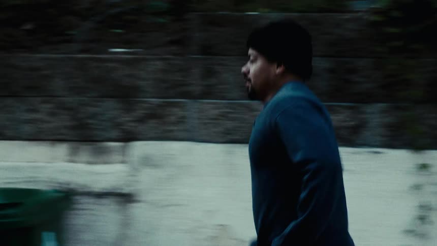 Man in cap running outdoors through city