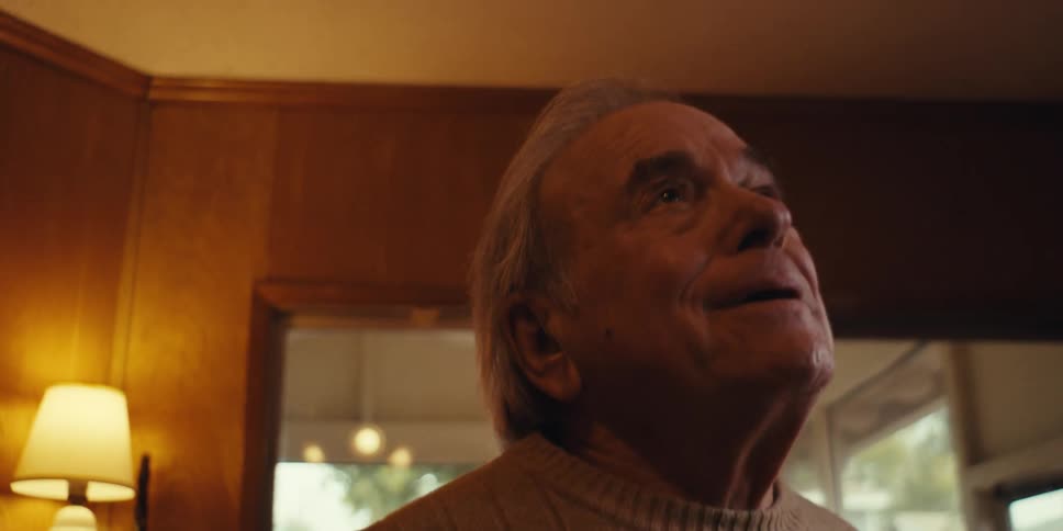Closeup of an elderly man singing and dancing alone in the living room of a cozy home