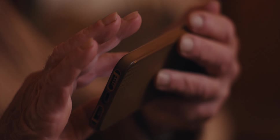 Pair of hands interacting with an iphone turned sideways