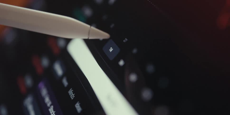 A stylus pen navigates a stock market app displaying a fluctuating graph on a tablet screen