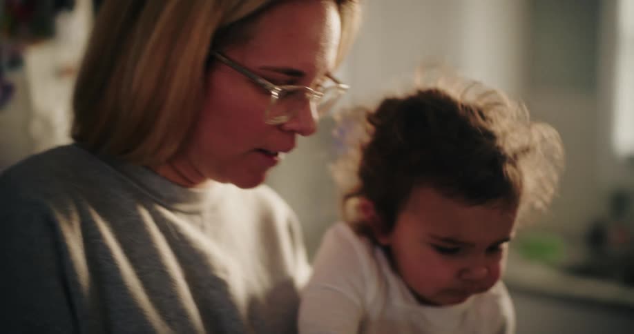 A child claps her hands as her mom cooks