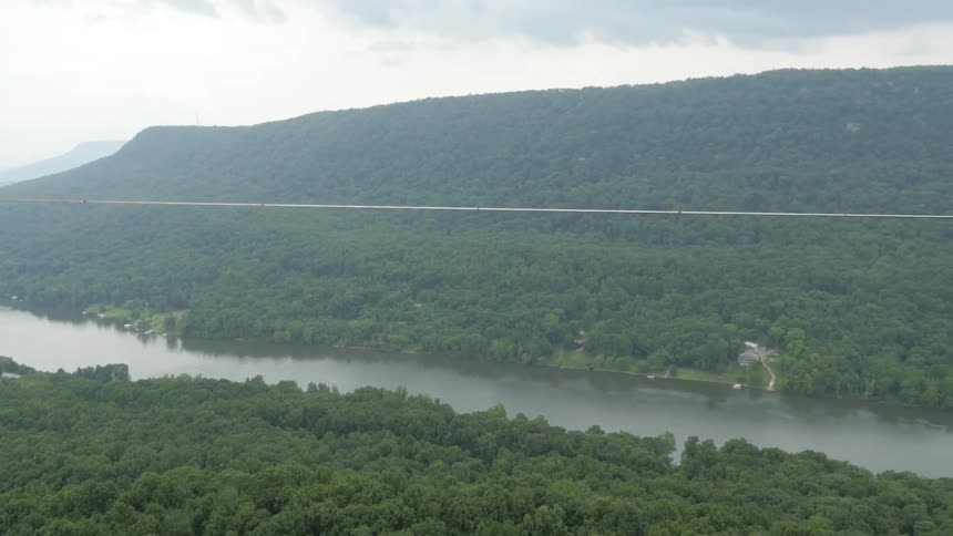 A man balances on a tightrope in a canyon