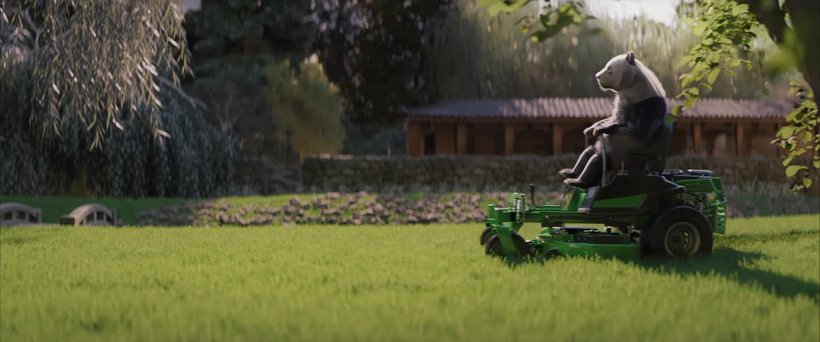 Bear riding on a lawn mower across a green lawn