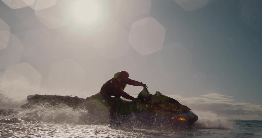 A man is driving his jet ski in the ocean
