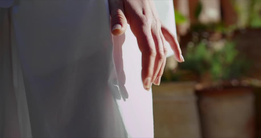 Fingers tapping on a wall outdoors in the sunlight