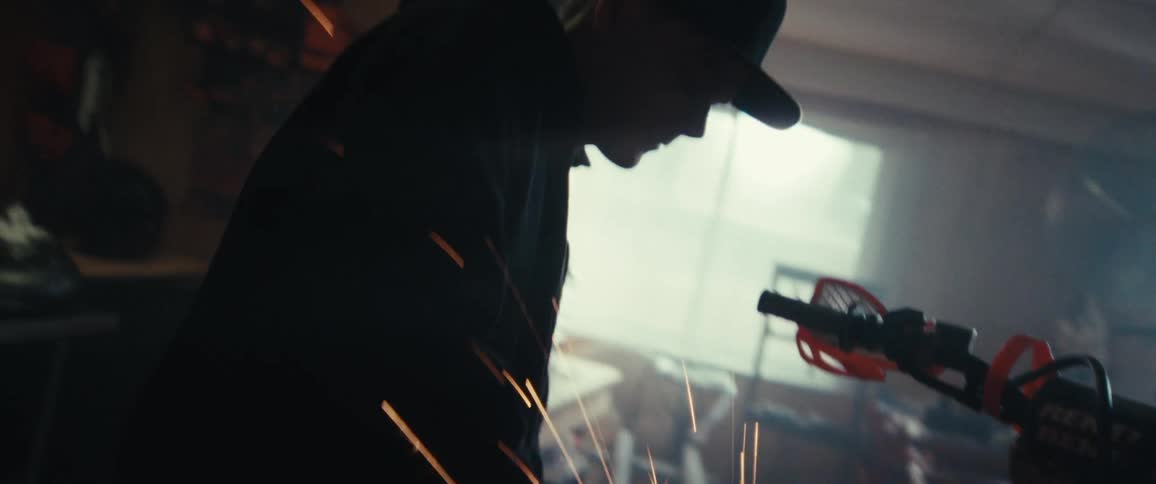 Man with a tool polishing the side of a motorcycle in a workshop