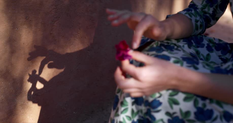A woman is touching the petals on a flower