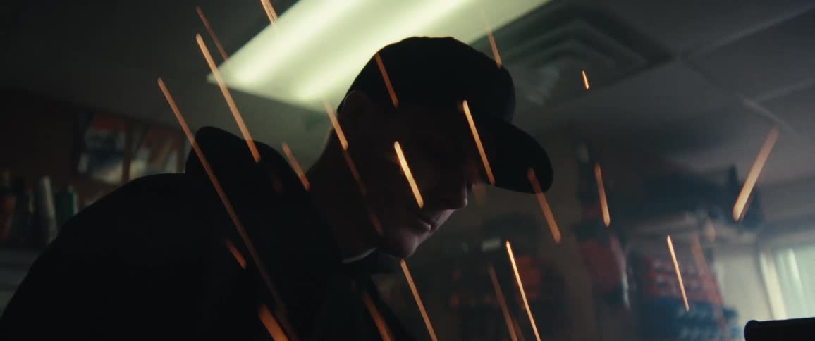 Portrait of a man in a cap working with sparks flying nearby