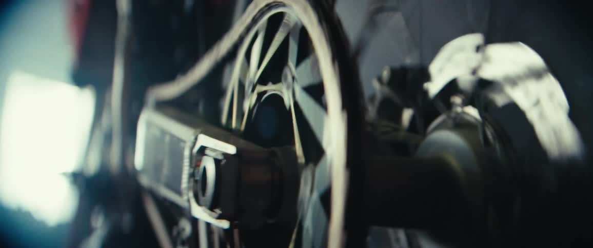 A closeup view of a spinning motorcycle wheel and its connecting rod mechanism