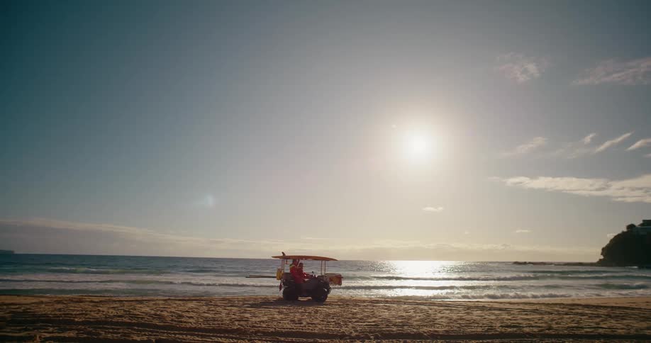 Two people riding a buggy on the sand at the beach