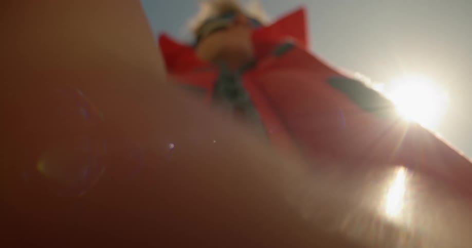 Point of view of a mans hand unzipping a red jacket
