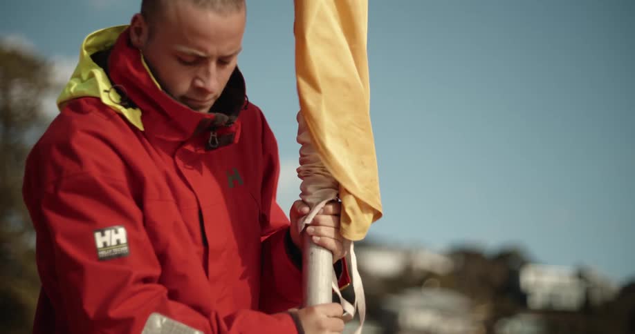 A lifeguard is planting a yellow and red flag on a beach on a sunny day