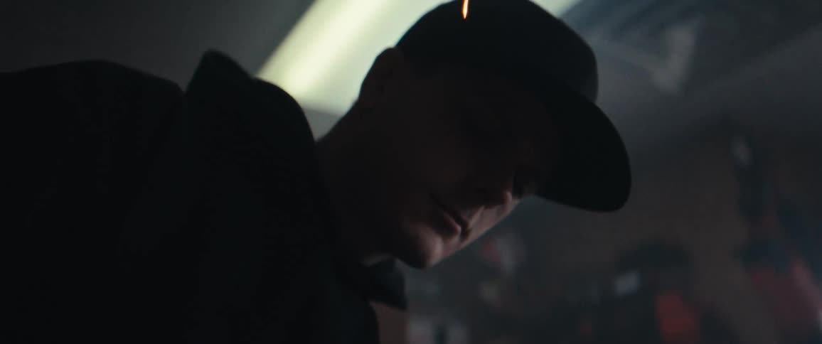A person wearing a cap is partially visible through streaks of light or sparks