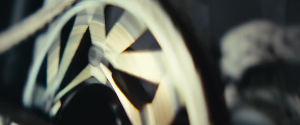 A closeup view shows a bike chain looping through the spokes of a rear wheel as it cycles