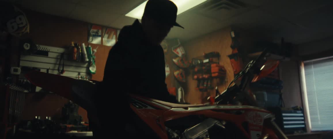 A mechanic stands up a dirt bike in the shop