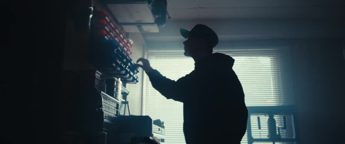 A man is searching through his tools in the workshop