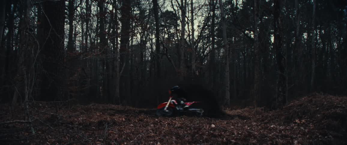 Man operating a motorcycle drives off road through the forest
