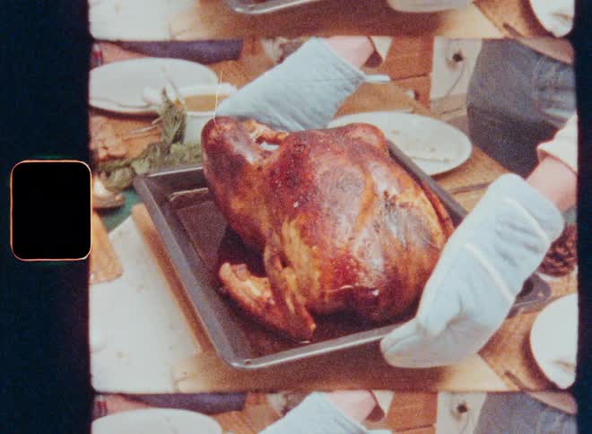 A man places a turkey on the dining table