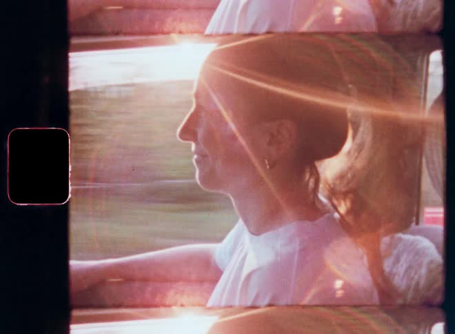 A woman is smiling while riding in the car