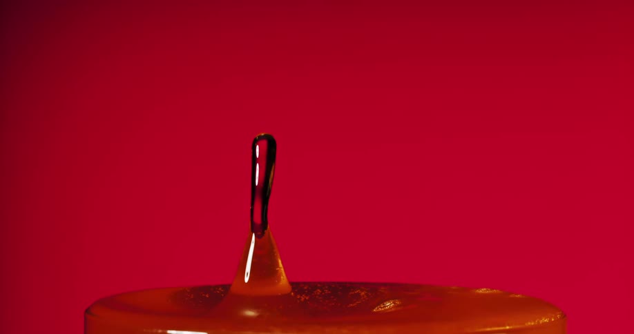 Liquid falls into the full glass