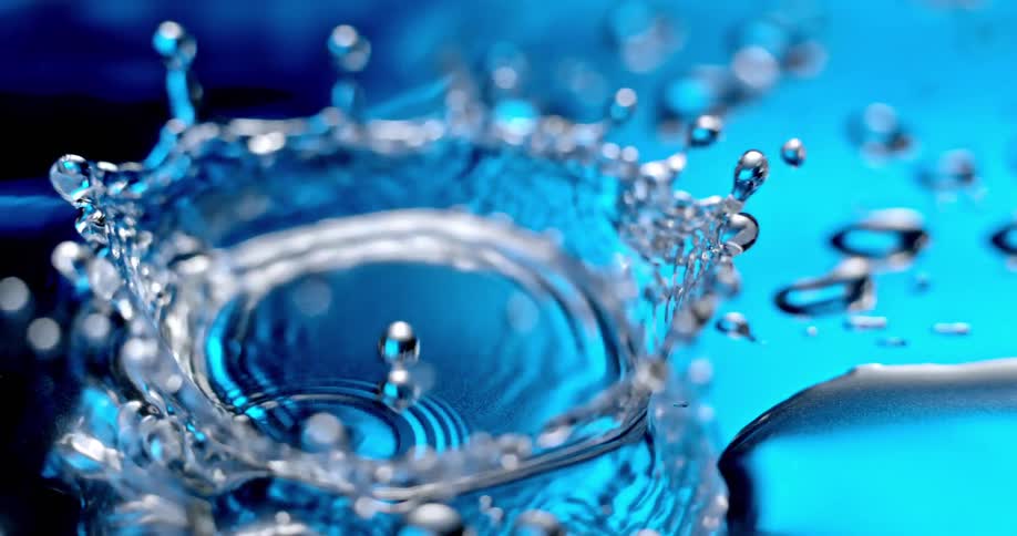 Water droplets and ripples on a vibrant blue surface