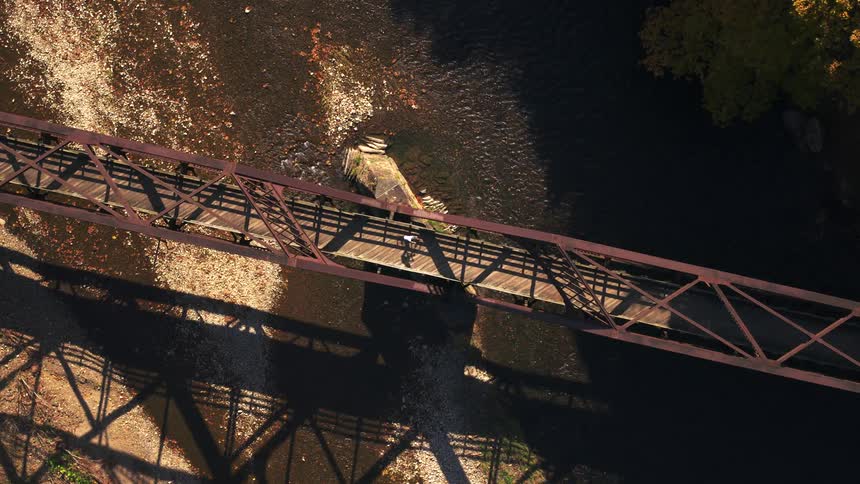 A person rides their bike over the stream