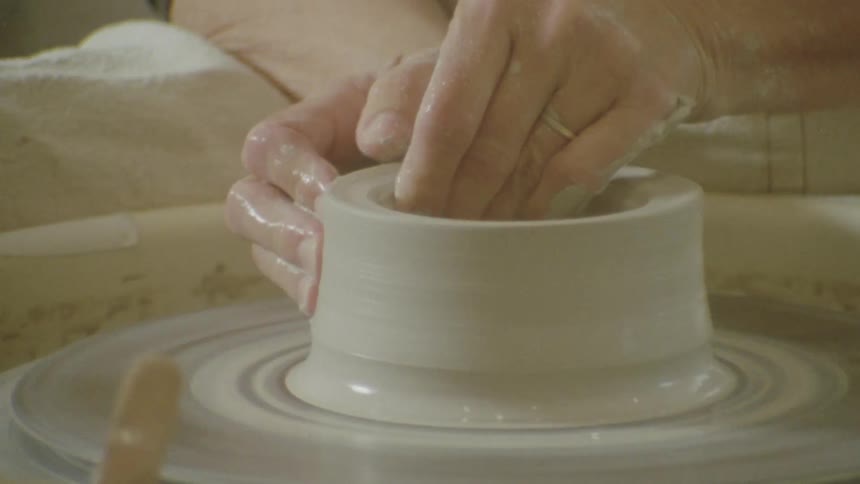 Pair of hands making a clay vase