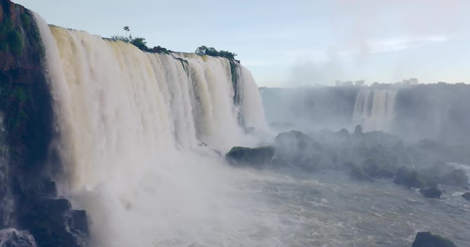 Water flows powerfully at a waterfall creating mist in a natural outdoor setting