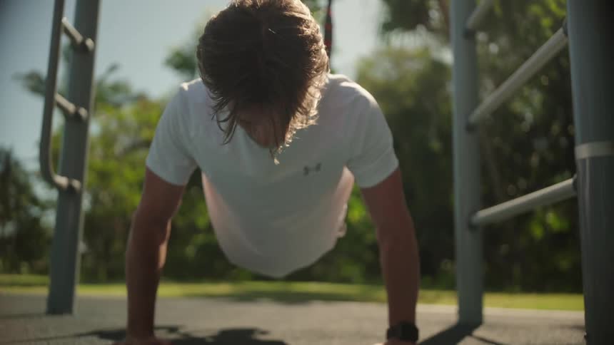 A man is doing pushups in the park