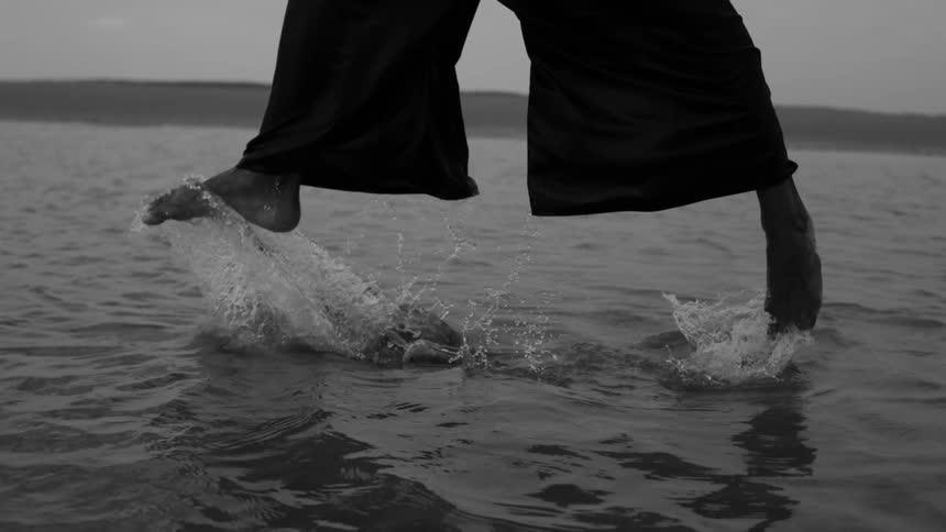 A man jumps high in the waters of the beach
