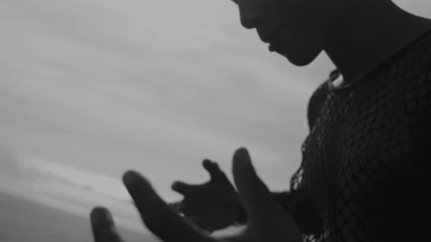 A person standing in leaky clothing and raising his hands
